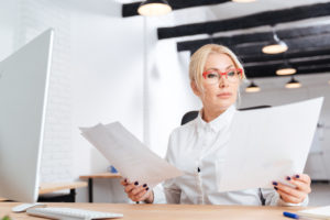 Woman at desk looking at business license document