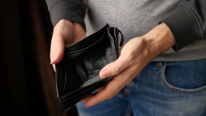 Is your stock media company ripping you off - Image of man's hands holding open an empty black wallet.